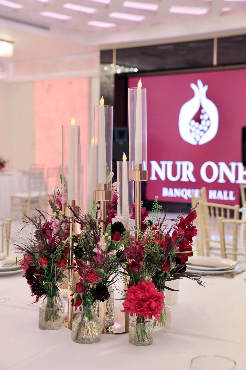 Floral centerpiece and candlelight at Nur One Banquet Hall
